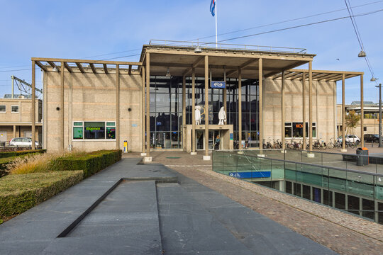 The Brutalist architecture of Zutphen train station in the Netherlands, featuring a prominent concrete canopy, glass facade, and a wide public plaza. Zutphen Netherlands, 7 November 2025.