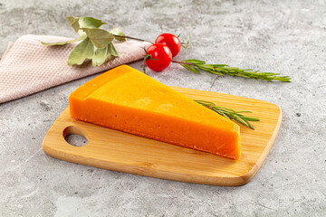 Yellow cheddar cheese over board