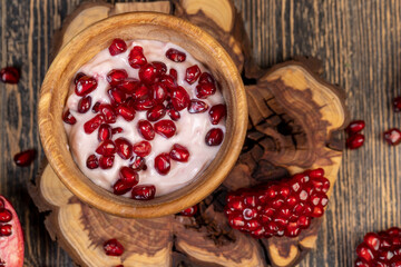 delicious fresh pink yogurt and ripe red pomegranate seeds, delicious pomegranate-flavored yogurt and fresh ripe red pomegranate seeds