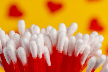 sticks with white cotton for hygienic procedures, red plastic sticks with natural white cotton at the ends for personal hygiene, close up