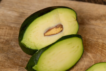 a fresh green avocado cut into pieces, a green avocado with soft flesh cut into pieces long ago, the seed has changed color from the air