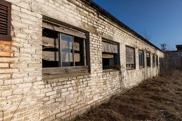 abandoned building made of brick in the winter, an abandoned building intended for demolition, the entrances and windows to the building are boarded up, close up