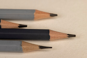 a row of black wooden pencils folded on cheap paper, wooden pencils with graphite lead for drawing or other work