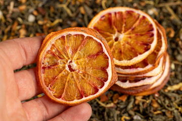 high-quality green tea with added flavors and pieces of fruit and cut dried red oranges, bright large dry slices of blood red orange and green tea, close up
