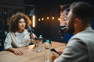 Two content creators recording podcast in modern studio
