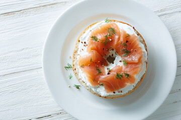 Toasted bagel with smooth cream cheese and smoked salmon layered on top, finished with dill and served on a white plate for modern breakfast imagery.