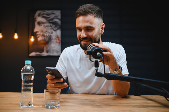 Content creator recording podcast in home studio with smartphone and microphone