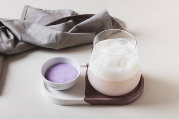 Cloudy pink matcha in a glass and powder in a bowl on the table