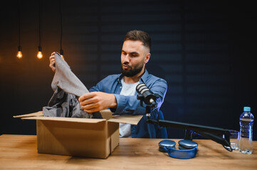 Video blogger unboxing clothing for online product review