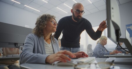 Mature Woman Sits at Desk, Focused on Computer Screen as Instructor Explains Corrections and Provides Feedback. Concept Collaboration, Learning Support, Adult Retraining, Digital Skill Improvement.