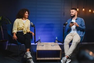 Podcasters recording audio content in modern studio