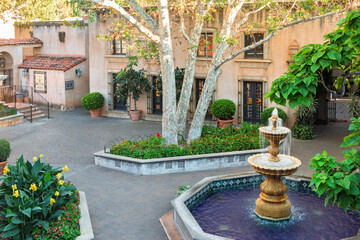 View of the North Courtyard with a fountain, large trees, shops, and art gallery buildings, at Mexican-styled Talaquepaque Arts Village, Sedona, AZ. USA.
