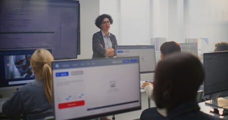 Female Teacher Stands By Large Screen Displaying Programming Code, Explaining Modeling Concepts to Adult Students. Concept Digital Education, Coding Skills, Modern Professional Learning Environment.