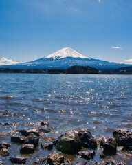 Lake Kawaguchiko, Japan - March 14 2025: Tourists enjoying the view of Lake Kawaguchiko with Mount Fuji in the background. Famous scenery of Mount Fuji in Japan. Blue skies on a cold sunny morning.