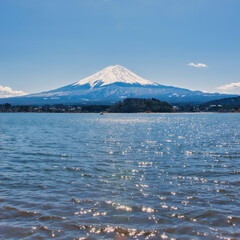 Lake Kawaguchiko, Japan - March 14 2025: Tourists enjoying the view of Lake Kawaguchiko with Mount Fuji in the background. Famous scenery of Mount Fuji in Japan. Blue skies on a cold sunny morning.