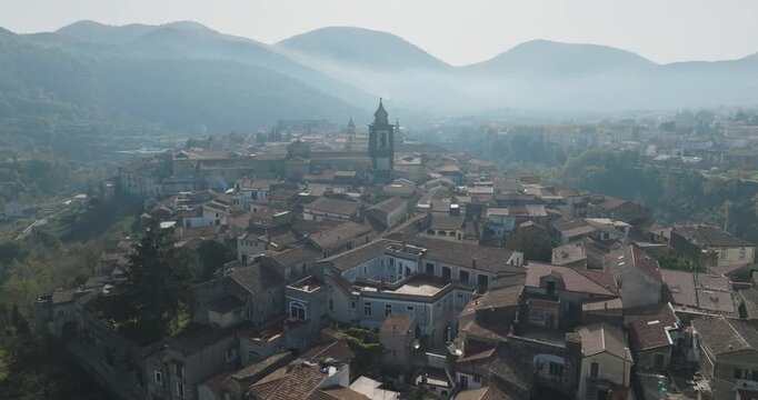 Aerial view of the old town with terracotta rooftops and the church tower amid rolling hills in the distance, Sant Agata de Goti, Campania, Italy.
