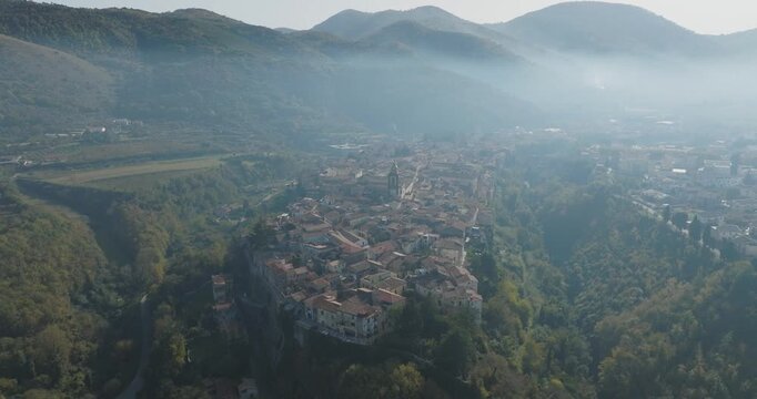 Aerial view of Sant Agata de Goti, a town perched amongst verdant hills, with terracotta roofs under a sky of pale blue, Sant Agata de Goti, Campania, Italy.