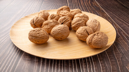 Walnuts, walnuts in their shells, and accessories positioned on a dark rustic table, Selective Focus.