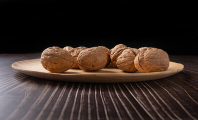 Walnuts, walnuts in their shells, and accessories positioned on a dark rustic table, Selective Focus.