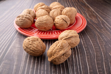 Walnuts, walnuts in their shells, and accessories positioned on a dark rustic table, Selective Focus.