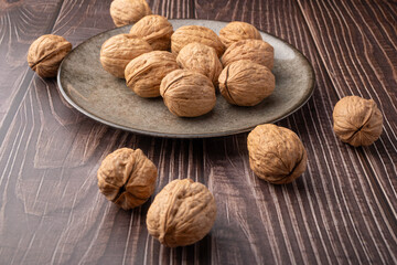 Walnuts, walnuts in their shells, and accessories positioned on a dark rustic table, Selective Focus.