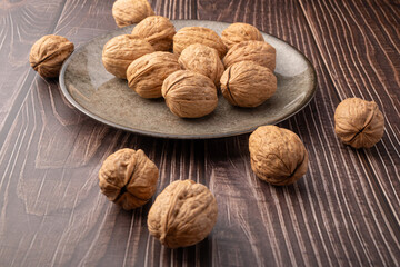 Walnuts, walnuts in their shells, and accessories positioned on a dark rustic table, Selective Focus.