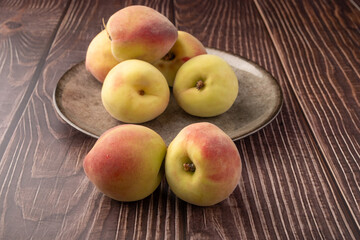 Peaches, beautiful peaches in a porcelain dish positioned on a rustic table, Selective Focus.