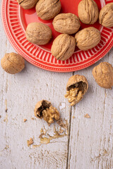 Walnuts, walnuts in their shells, and accessories positioned on a rustic table, top view.