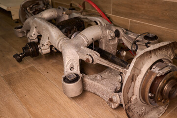 Vintage vehicle restoration, Old car parts under warm workshop lighting, Scene depicting classic vehicle undergoing restoration with rusted parts and scattered tools