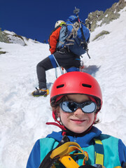 Selfie of a child climbing a mountain with his father.