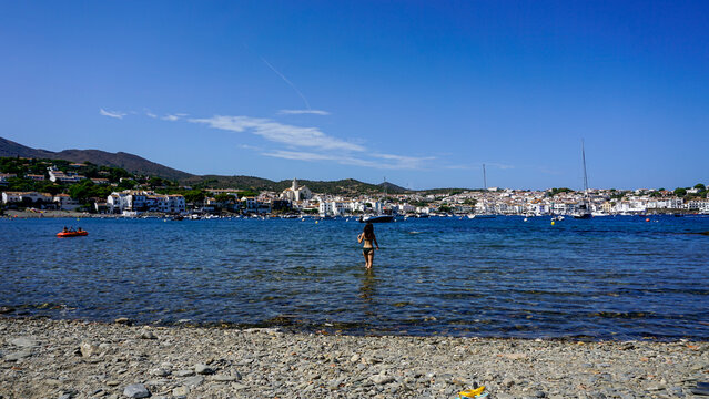 Woman walking into the Mediterranean Sea in Cadaques, Costa Brava, Catalonia, Spain