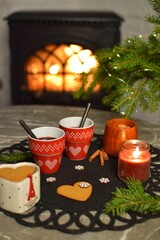 Two mugs of delicious mulled wine by the fireplace.