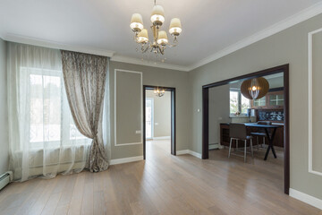 A spacious bright room without furniture. The interior of the kitchen in the archway.
