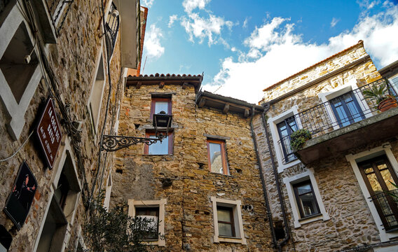 Windows of 15th century buildings in the he hilltop town of Perinaldo, Italy reflect the blue sky above the mountain village that draws thousands of tourists to see its medieval setting.