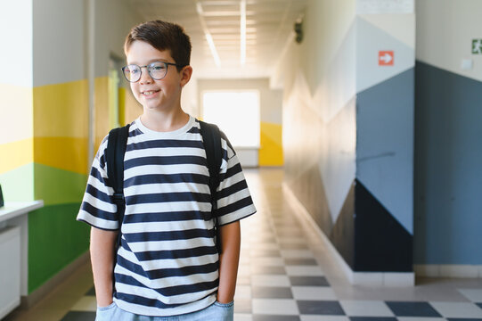 Smiling pupil walking in school hallway during break time