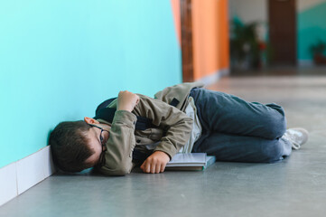 Fototapeta premium Schoolboy crying on floor after bullying incident at school