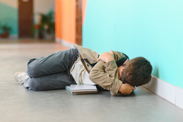 Obraz premium Schoolboy crying on floor after bullying incident at school