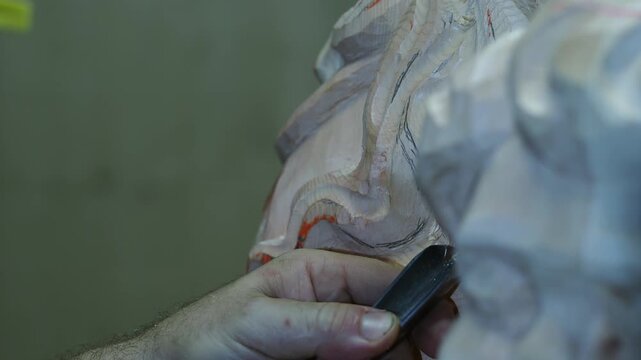 Skilled carpenter carving a wooden sculpture