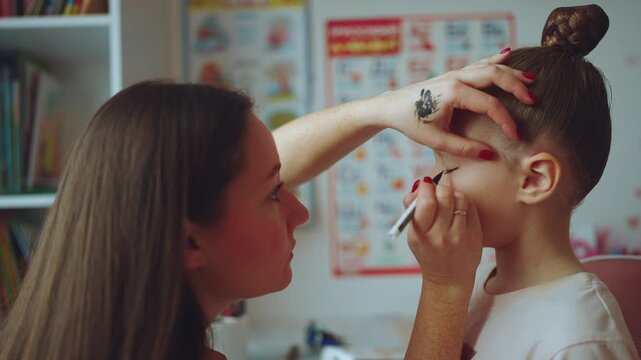Mom makes up for her daughter, a little girl gets makeup, a girl gets eye makeup