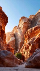 Sunlit red rock canyon with towering cliffs and clear blue sky in desert landscape