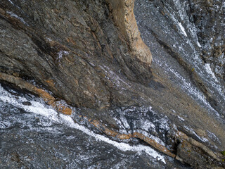 Rugged Rock Face With Snow Patches and Layered Cliff Formations in BC Canada © edb3_16