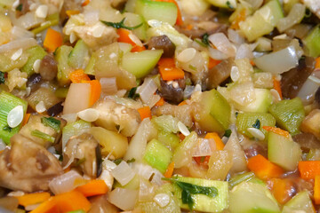 Vegetable stew is cooked on gas stove in metal pan. Vegetable ragout