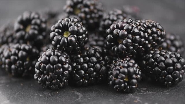 Blackberry closeup, blackberries background. Fresh Ripe organic black berries rotating over gray backdrop, close-up. Macro shot. Market. Vegan food. 