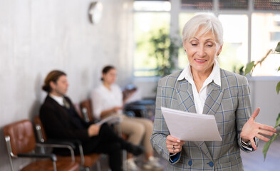 Excited mature female office worker rejoices at her success