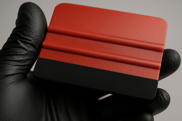 Squeegee Tool Close-Up: A detailed close-up shot showcases a professional squeegee tool held by gloved hand. The tool's design suggests precision and skill