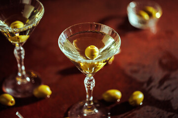 A fashionable cocktail moment with a martini glass and olives, reflecting warm evening lights.