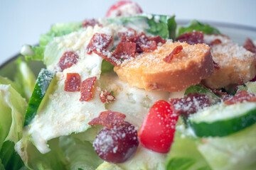 Close up of Caesar Salad: Crisp romaine lettuce tossed with Parmesan, croutons, and a creamy Caesar dressing,