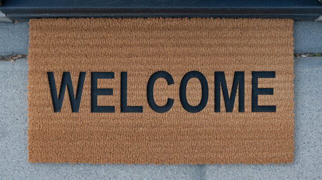 Welcome home with a stylish door mat greeting guests warmly at the front door, offering a friendly invitation and a sense of hospitality and comfort