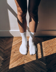 Minimal Lifestyle Socks, Clean White Crew Socks in Natural Sunlight on Warm Wooden Floor