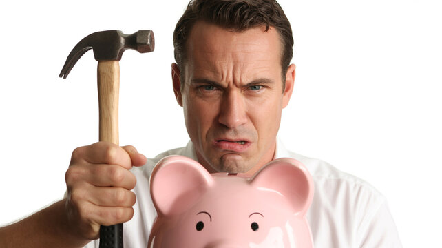 Frustrated man smashing piggy bank with hammer representing financial stress and savings depletion during economic hardship and recession fears